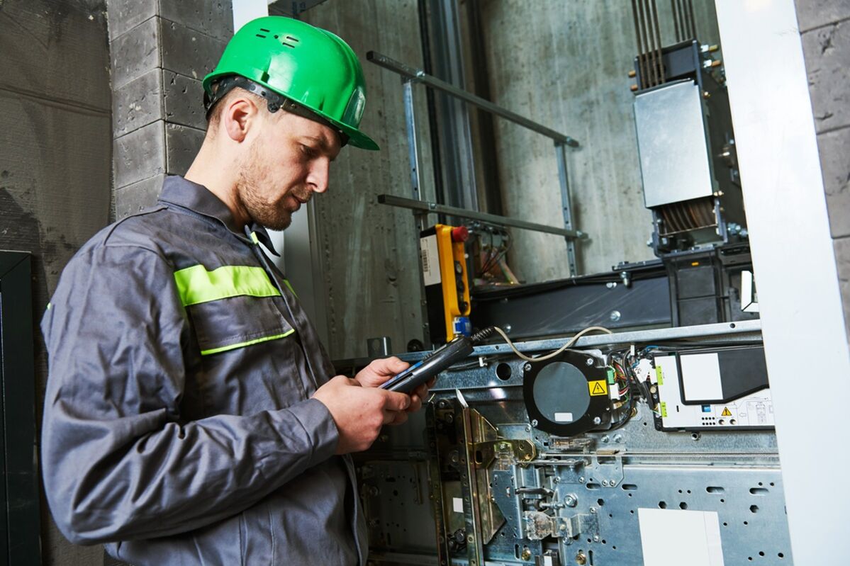 An engineer repairing a lift